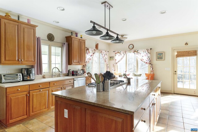 kitchen with a kitchen island, ornamental molding, stainless steel appliances, and a sink