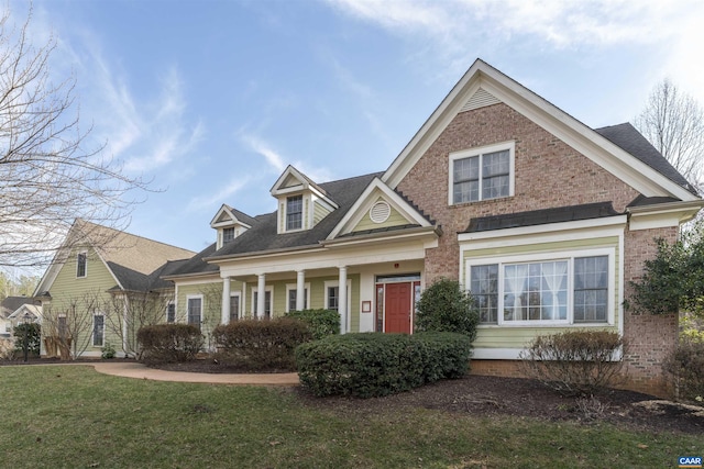 view of front of house featuring brick siding and a front lawn