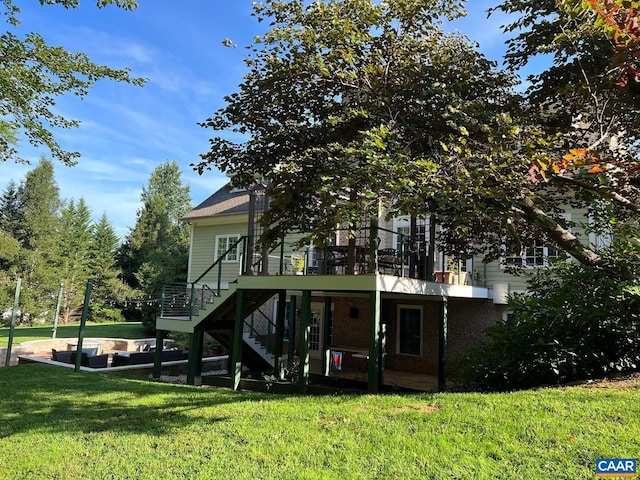 rear view of property featuring a deck, stairway, and a yard