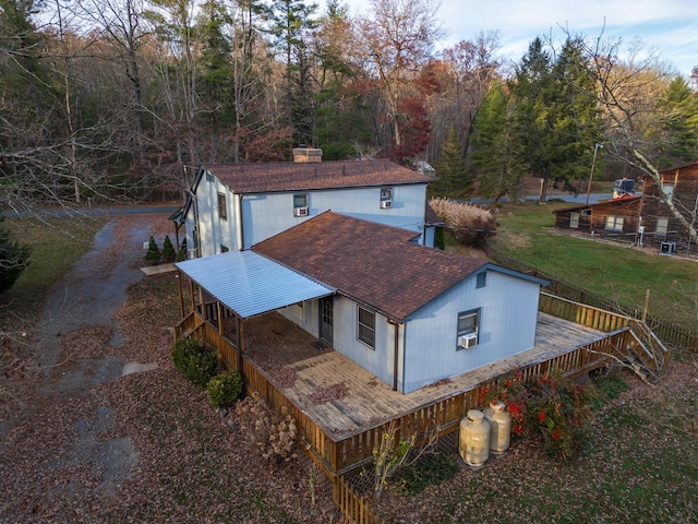 exterior space with a shingled roof and a deck