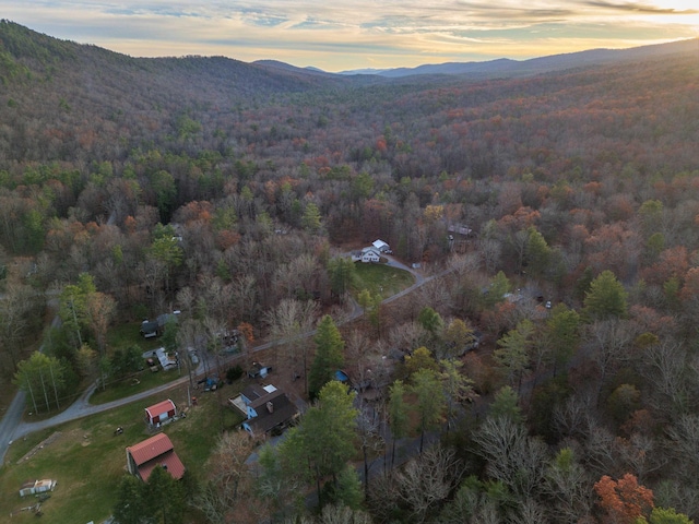 aerial view at dusk with a wooded view and a mountain view