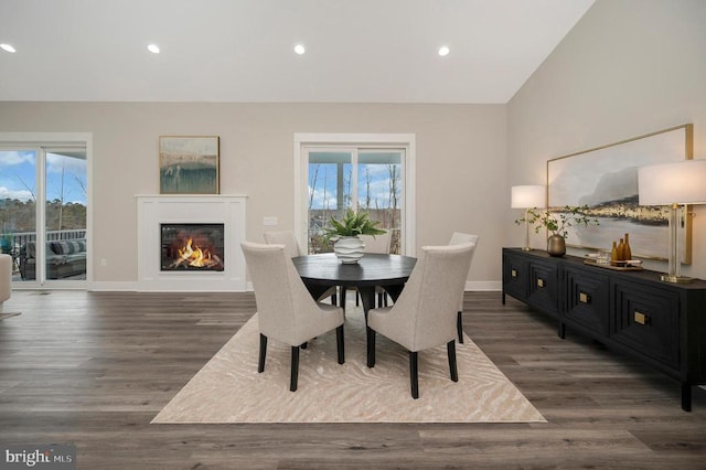 dining space featuring dark wood-type flooring and vaulted ceiling