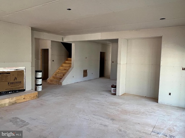 unfurnished living room featuring stairway