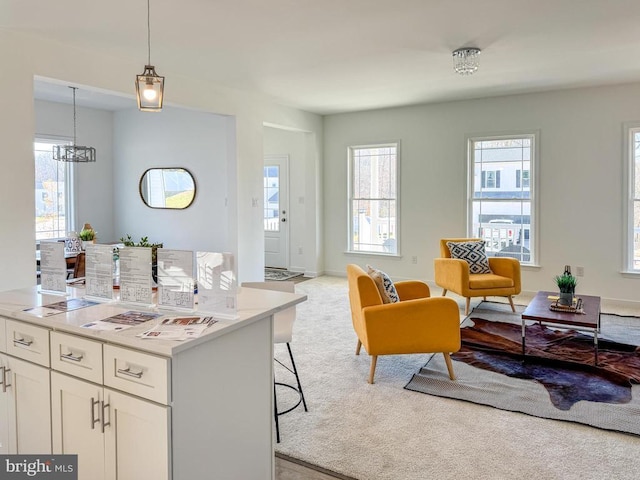 kitchen with a wealth of natural light, light colored carpet, open floor plan, and white cabinets