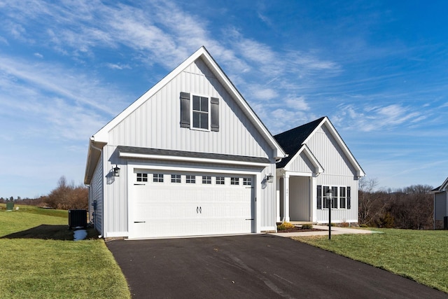 modern inspired farmhouse with aphalt driveway, a front lawn, board and batten siding, and central air condition unit