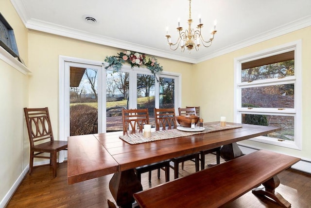 dining room featuring ornamental molding, a chandelier, dark hardwood / wood-style floors, and plenty of natural light