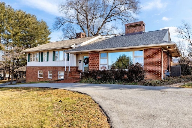 view of front of property featuring a front yard and central AC unit