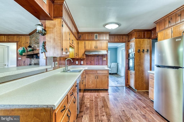 kitchen featuring crown molding, light countertops, appliances with stainless steel finishes, and a sink