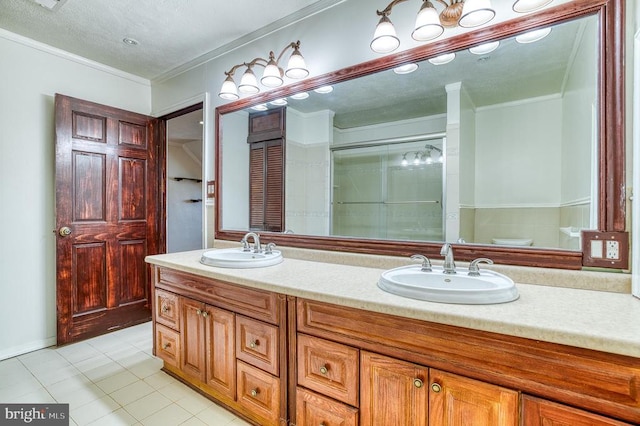 full bath featuring double vanity, tile patterned floors, crown molding, and a sink