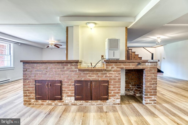 living room with light wood-type flooring, a ceiling fan, a brick fireplace, and stairs