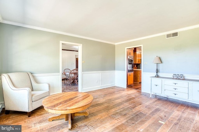 sitting room with a wainscoted wall and light wood-style floors