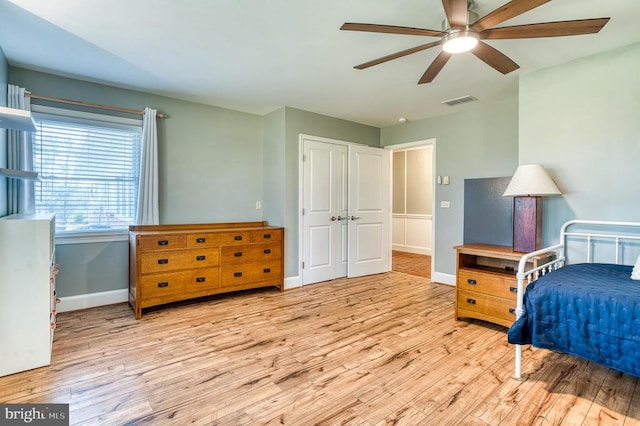 bedroom with wood finished floors, visible vents, and baseboards