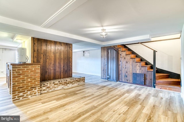 unfurnished living room with stairway and wood finished floors