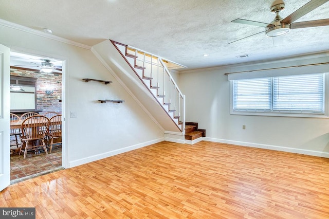 interior space featuring stairway, a textured ceiling, ceiling fan, and ornamental molding