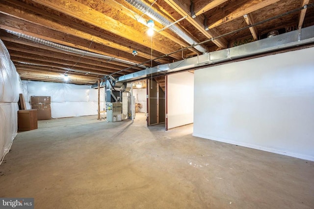 unfinished basement featuring heating unit and water heater