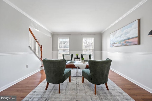 sitting room featuring wood finished floors, stairs, and ornamental molding