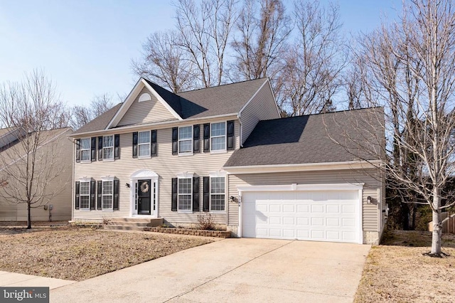 colonial home featuring a garage, driveway, and a shingled roof