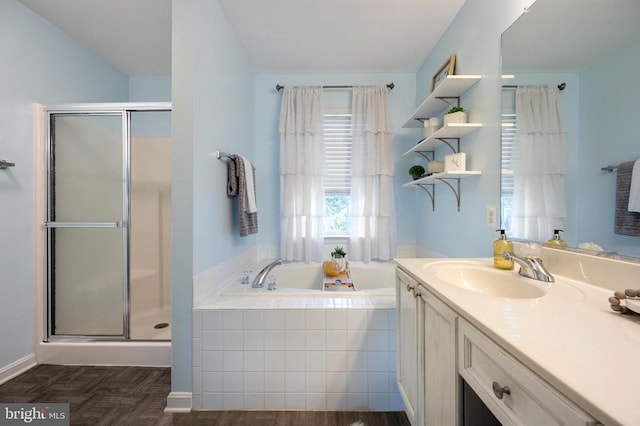 full bathroom with a stall shower, vanity, and a garden tub