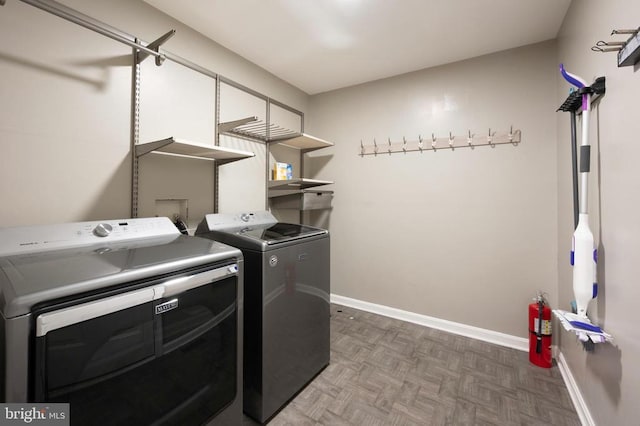 laundry area with laundry area, baseboards, and washer and clothes dryer