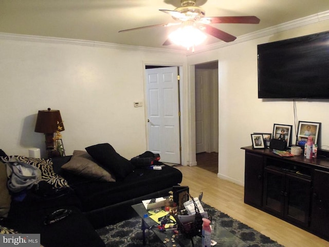 living area featuring baseboards, a ceiling fan, light wood-style floors, and ornamental molding