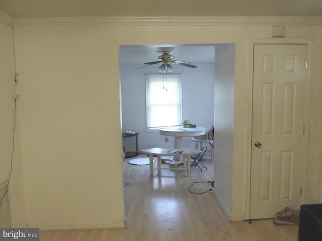 dining room featuring crown molding, light wood-style flooring, baseboards, and ceiling fan