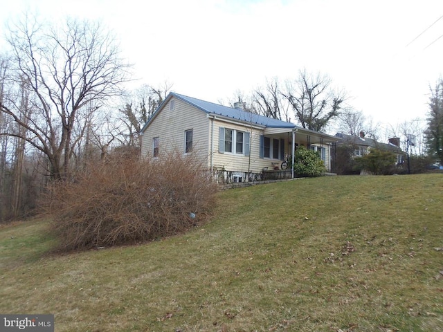 view of front of property with a front lawn, a chimney, and metal roof