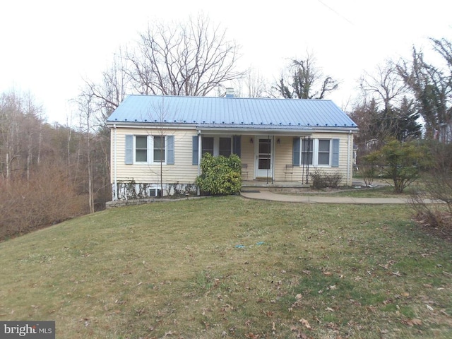 view of front of house with covered porch, metal roof, and a front lawn