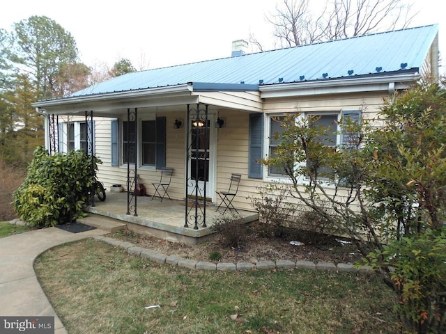 view of front of property featuring covered porch and metal roof