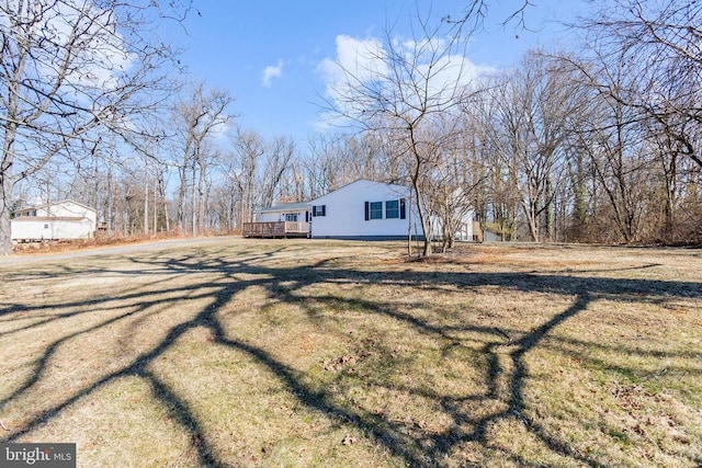 view of property exterior featuring a lawn and a wooden deck