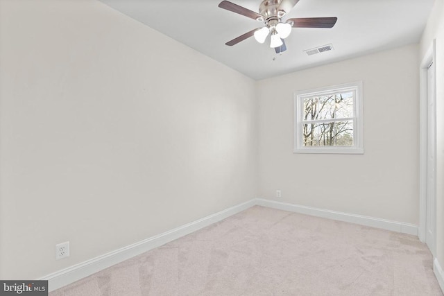 spare room with baseboards, a ceiling fan, visible vents, and light colored carpet