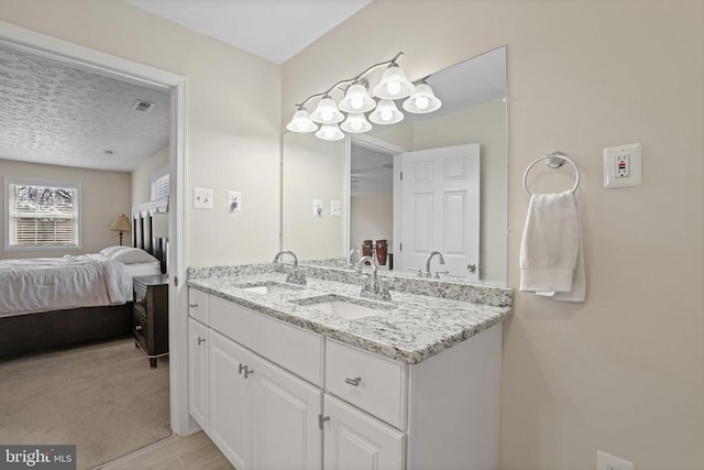 bathroom featuring connected bathroom, visible vents, a sink, and double vanity