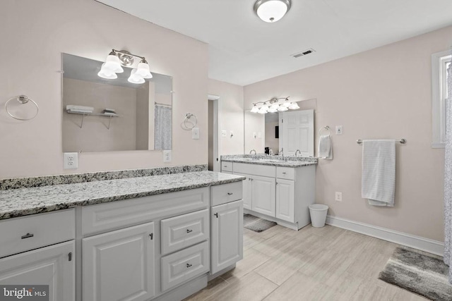 full bathroom with baseboards, visible vents, wood finished floors, and vanity