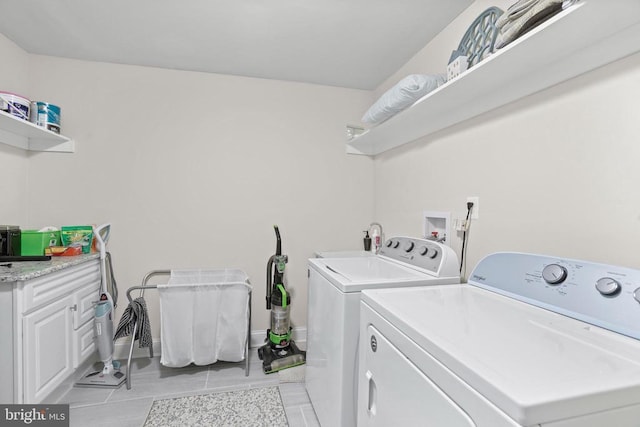 washroom with washing machine and dryer, cabinet space, and baseboards