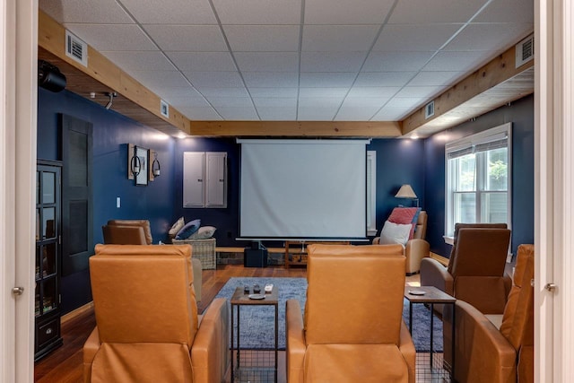 home theater room with hardwood / wood-style flooring and a drop ceiling