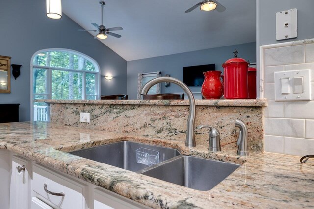 kitchen featuring white cabinetry, ceiling fan, vaulted ceiling, and sink