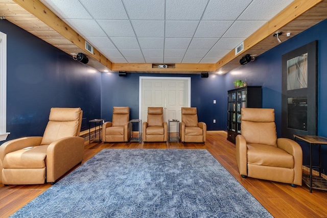 cinema featuring a drop ceiling and hardwood / wood-style floors