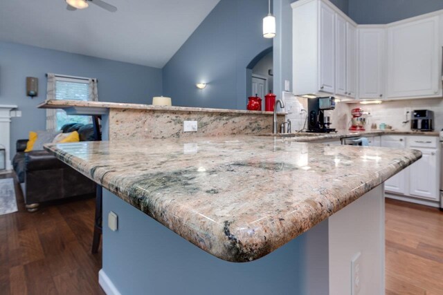 kitchen featuring white cabinetry, dark hardwood / wood-style floors, pendant lighting, and light stone counters