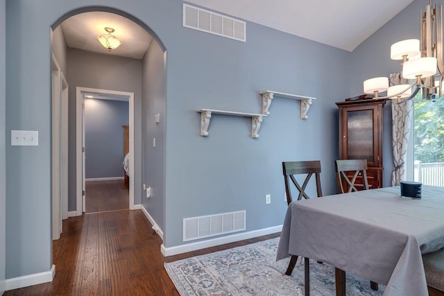 dining space with dark hardwood / wood-style floors and vaulted ceiling