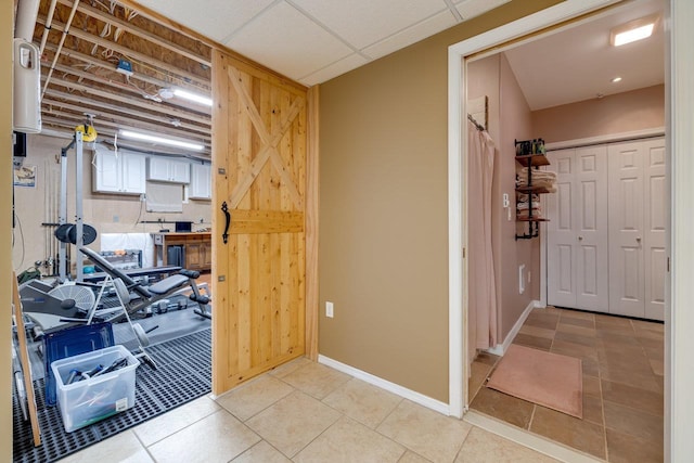 interior space featuring a paneled ceiling and light tile patterned floors