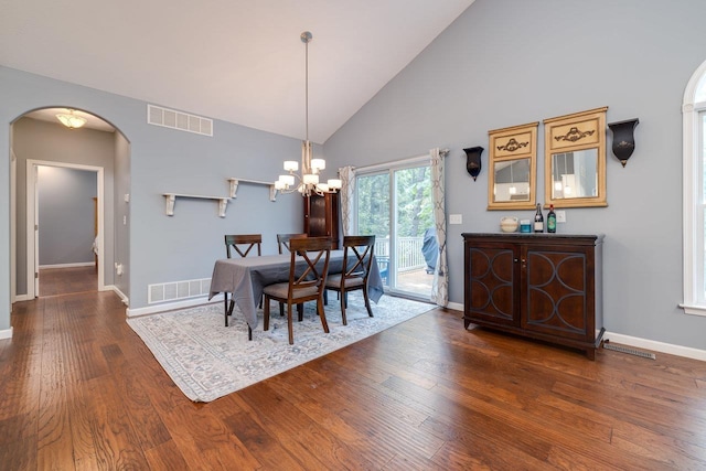 dining room with dark hardwood / wood-style floors, a chandelier, and high vaulted ceiling