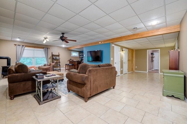 tiled living room featuring a drop ceiling and ceiling fan