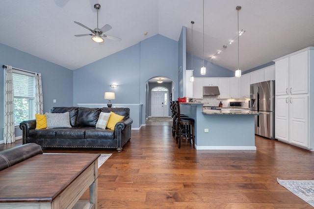 living room featuring ceiling fan, dark hardwood / wood-style flooring, and high vaulted ceiling