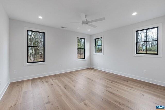 unfurnished room with visible vents, recessed lighting, light wood-type flooring, and baseboards