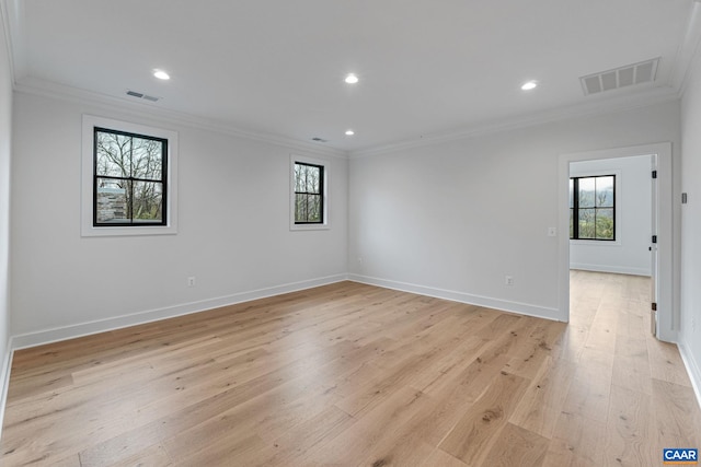 spare room featuring visible vents, light wood-type flooring, and crown molding