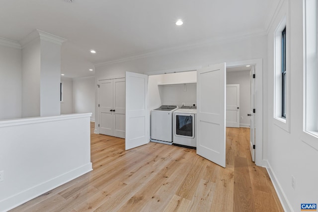 kitchen with a wealth of natural light, independent washer and dryer, ornamental molding, and light wood finished floors