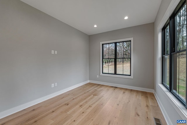 empty room with recessed lighting, visible vents, baseboards, and light wood finished floors