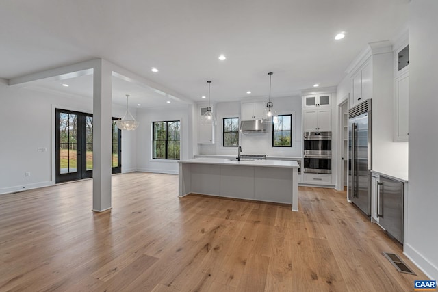 kitchen with visible vents, light countertops, appliances with stainless steel finishes, white cabinetry, and open floor plan