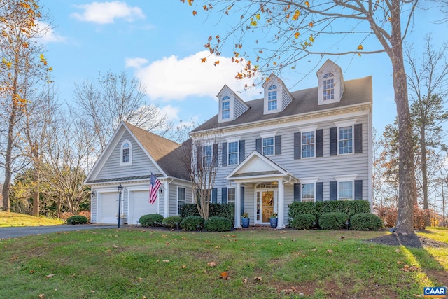 georgian-style home featuring a garage, a front yard, and driveway