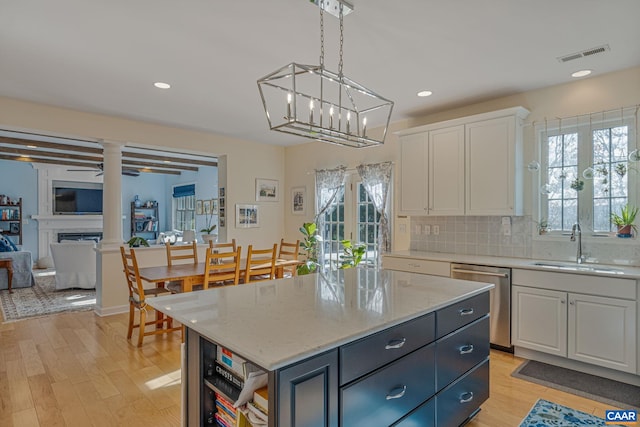 kitchen featuring visible vents, a sink, white cabinetry, dishwasher, and a healthy amount of sunlight