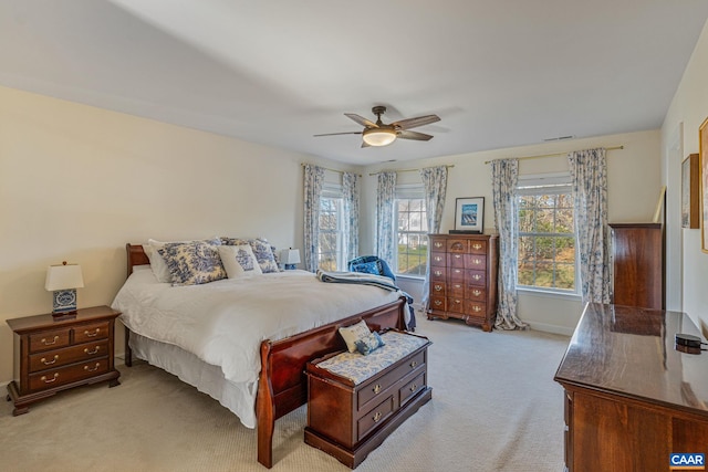 bedroom featuring light colored carpet, baseboards, and ceiling fan